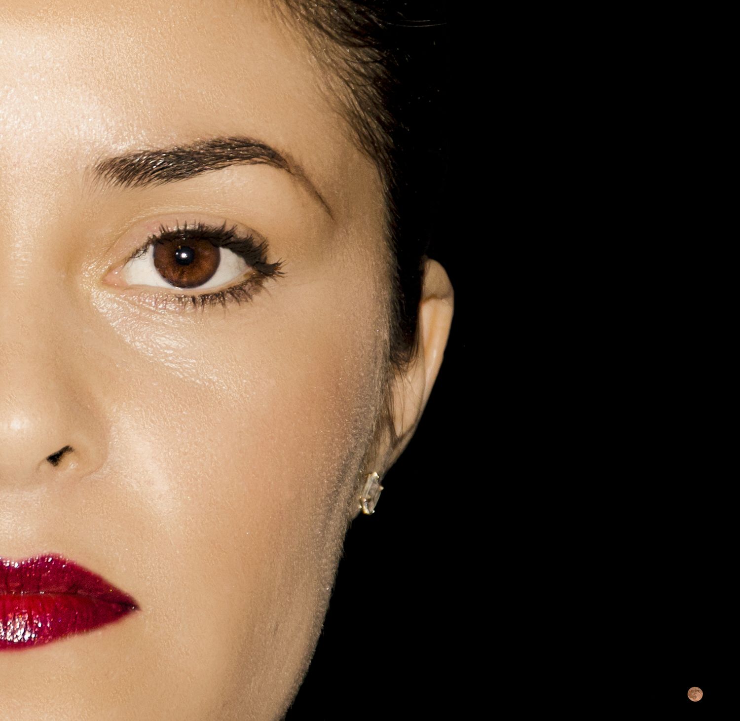 Close-up beauty shot showing dramatic red lipstick and makeup details.