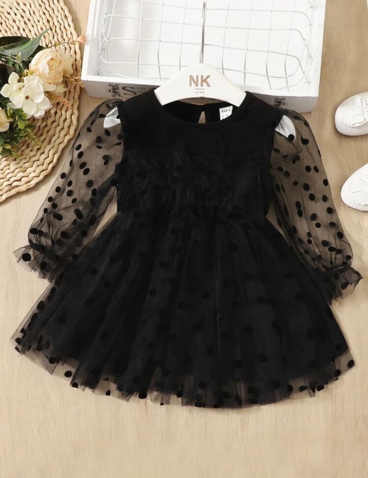 Black polka dot tulle dress with sheer sleeves and ruffled details.