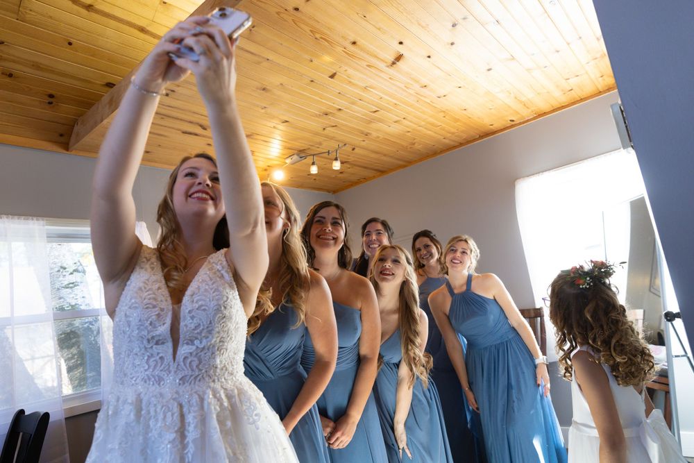 Wedding party celebrating in a bright room with wood-paneled ceiling.