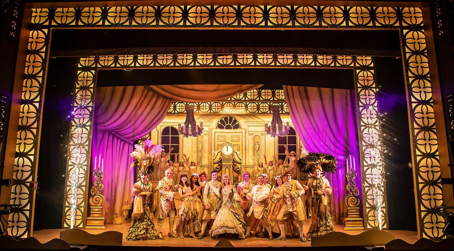 Ornate theater stage with golden architectural details and purple curtains during an ensemble performance scene.