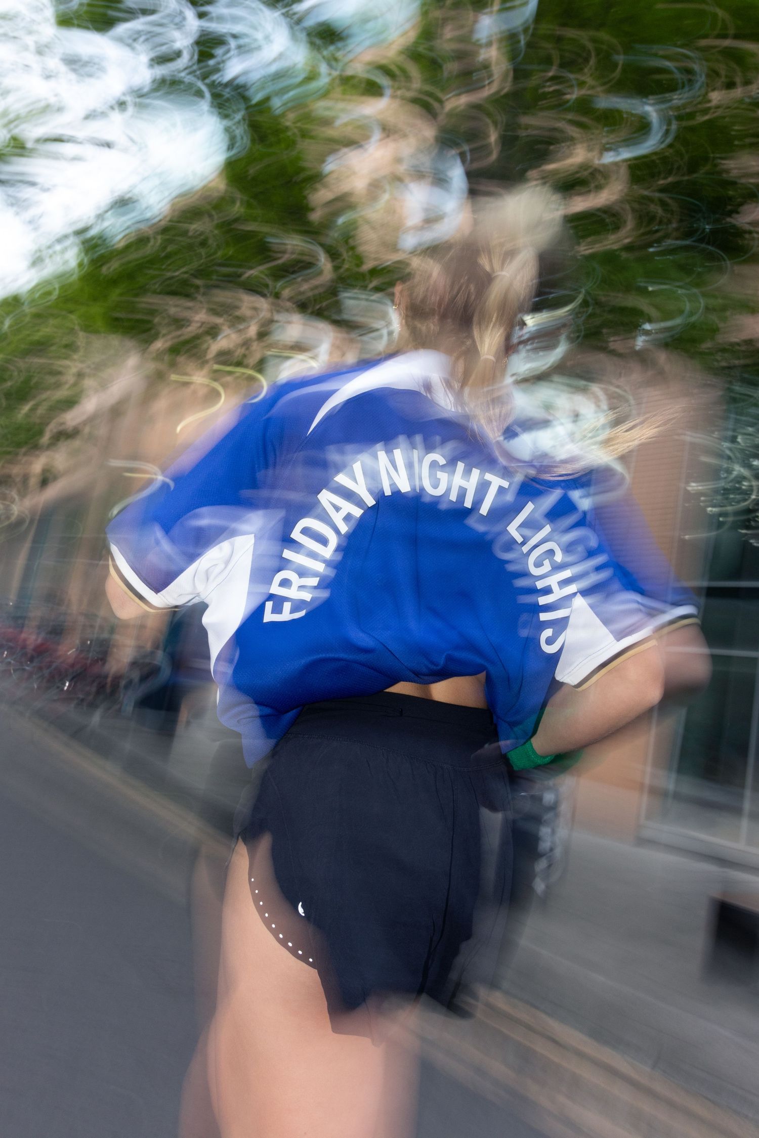 Motion-blurred image of runner in blue Friday Night Lights jersey.