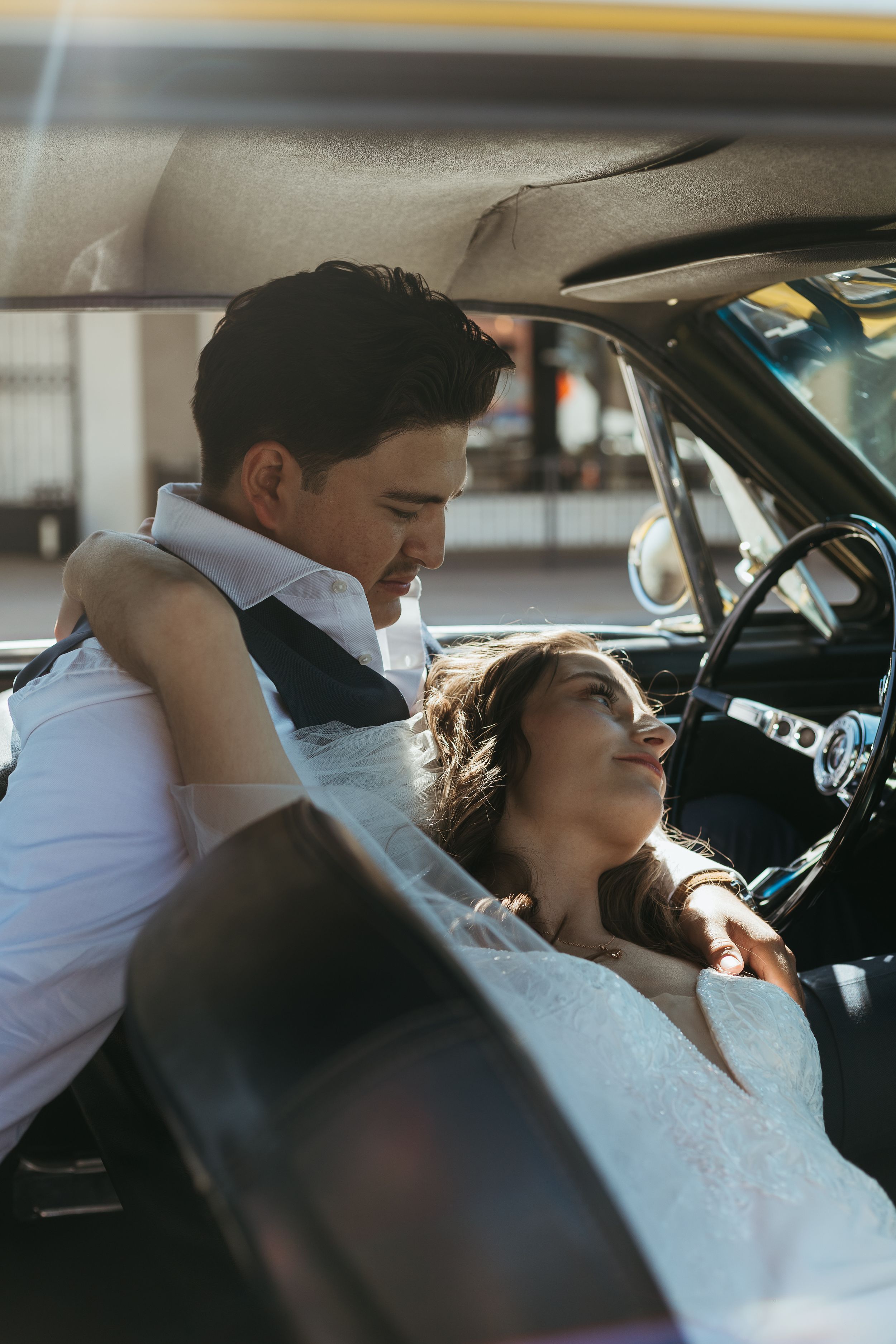 A tender moment between partners in vintage car after their wedding in Chandler Arizona