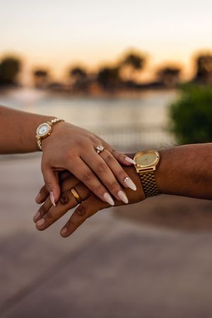 Hands with wedding rings and jewelry against sunset backdrop after a courthouse wedding in Peoria Arizona