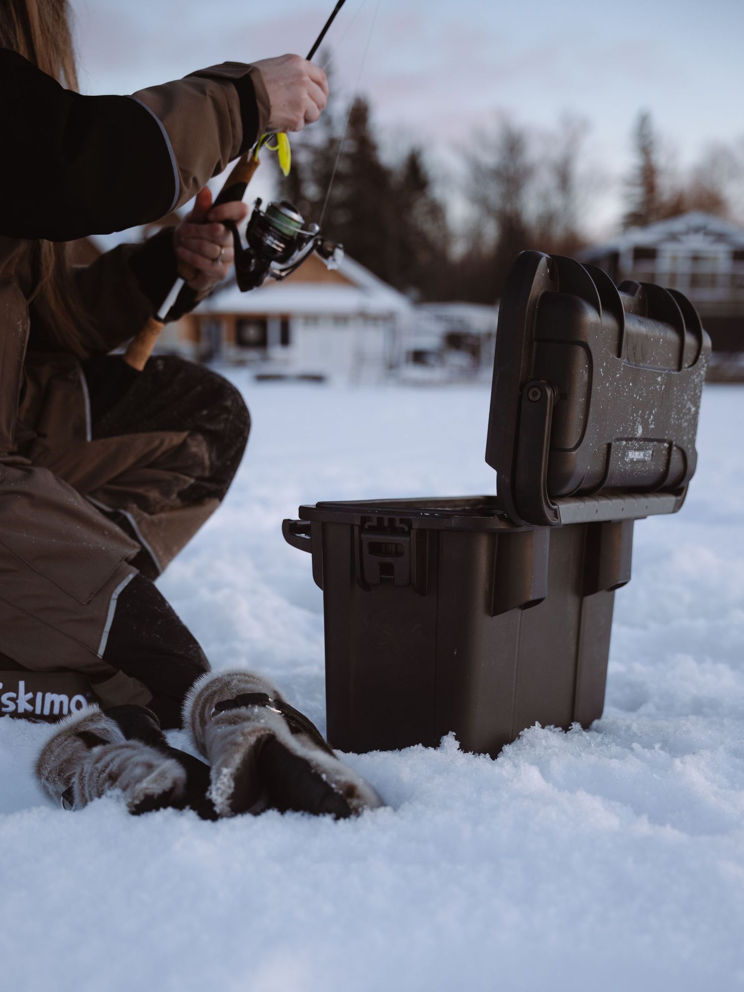 Close-up shots of fishing gear and equipment boxes positioned in snow.