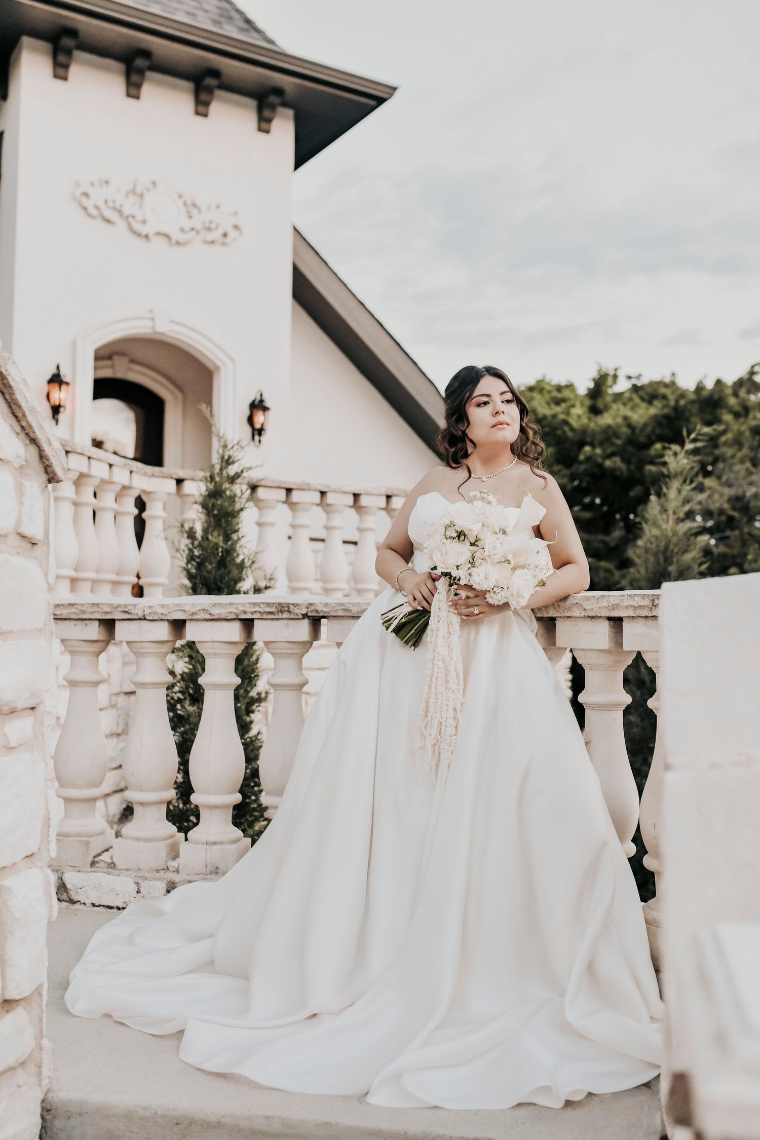 Bride looks over the balcony at sunset after their wedding ceremony