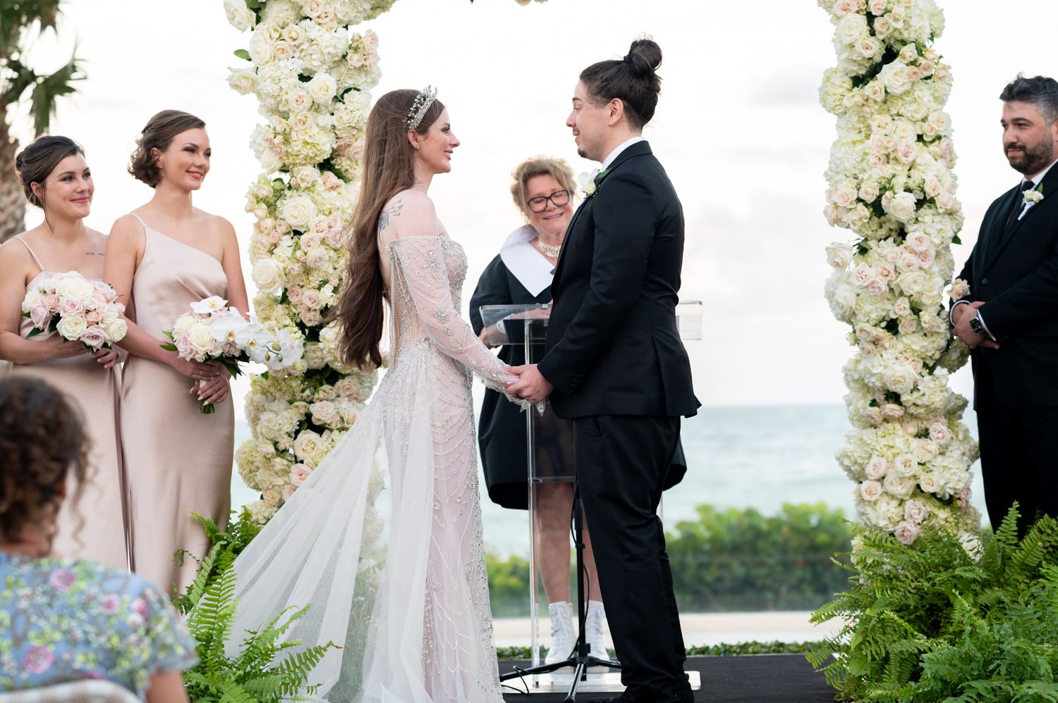 With the ocean as the backdrop during their wedding at sunset. This couple exchange their wedding vows before luxury wedding photographers