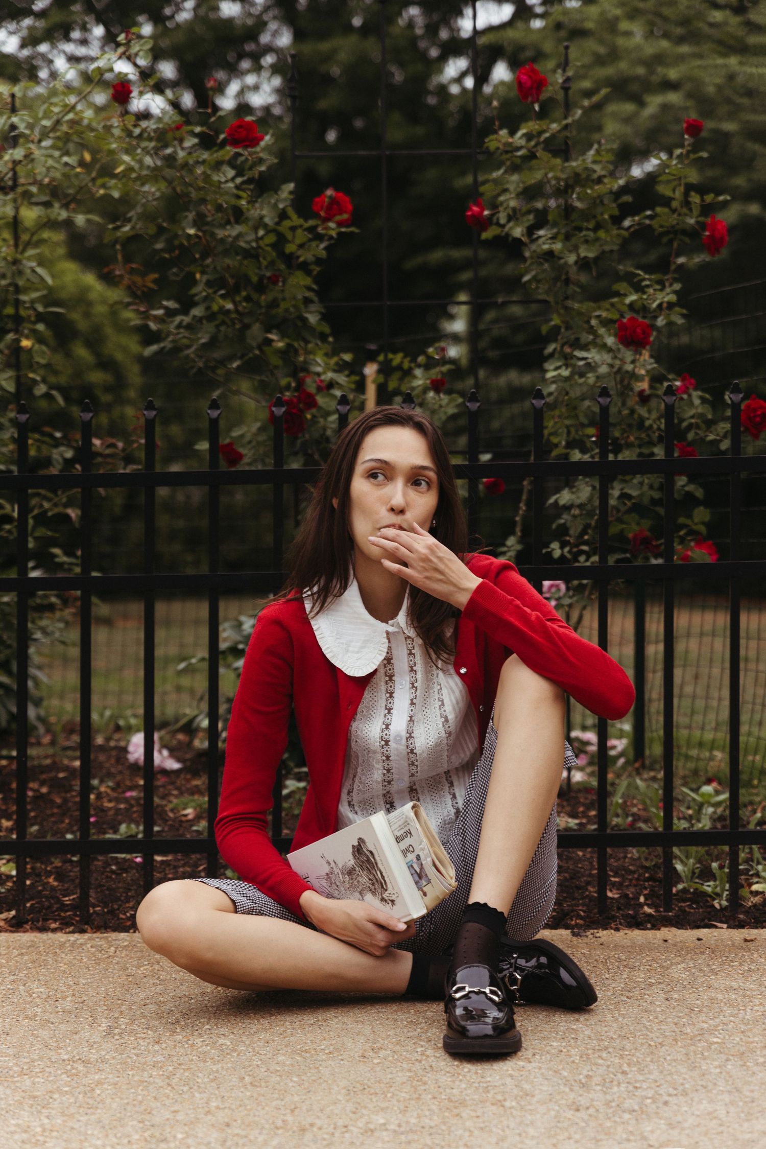 Editorial model sitting on sidewalk of historic neighborhood and wearing a vintage red sweater, Atlanta fashion photography