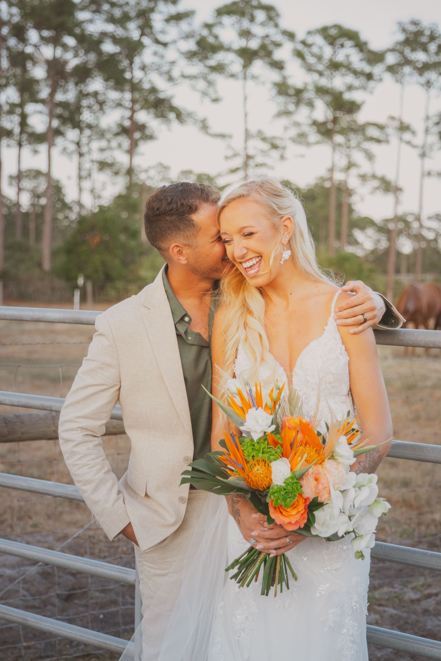 Bride Tilli of Tilli's Coffee Cart and her husband, Andrew, having a candid photo taken while leaning on a barn fence at Palmetto Flats