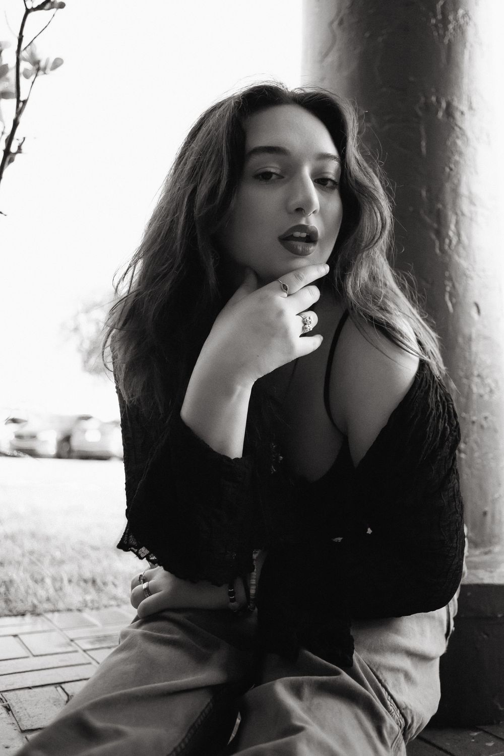 Fashion portrait of woman sitting on sidewalk at Hammocks Town Center in Miami