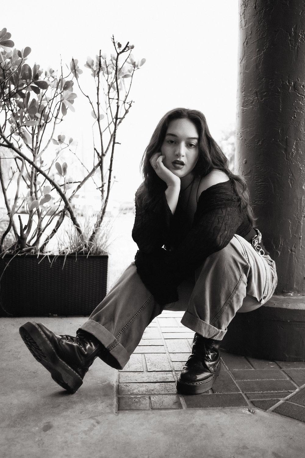 Fashion portrait of woman sitting on sidewalk at Hammocks Town Center in Miami