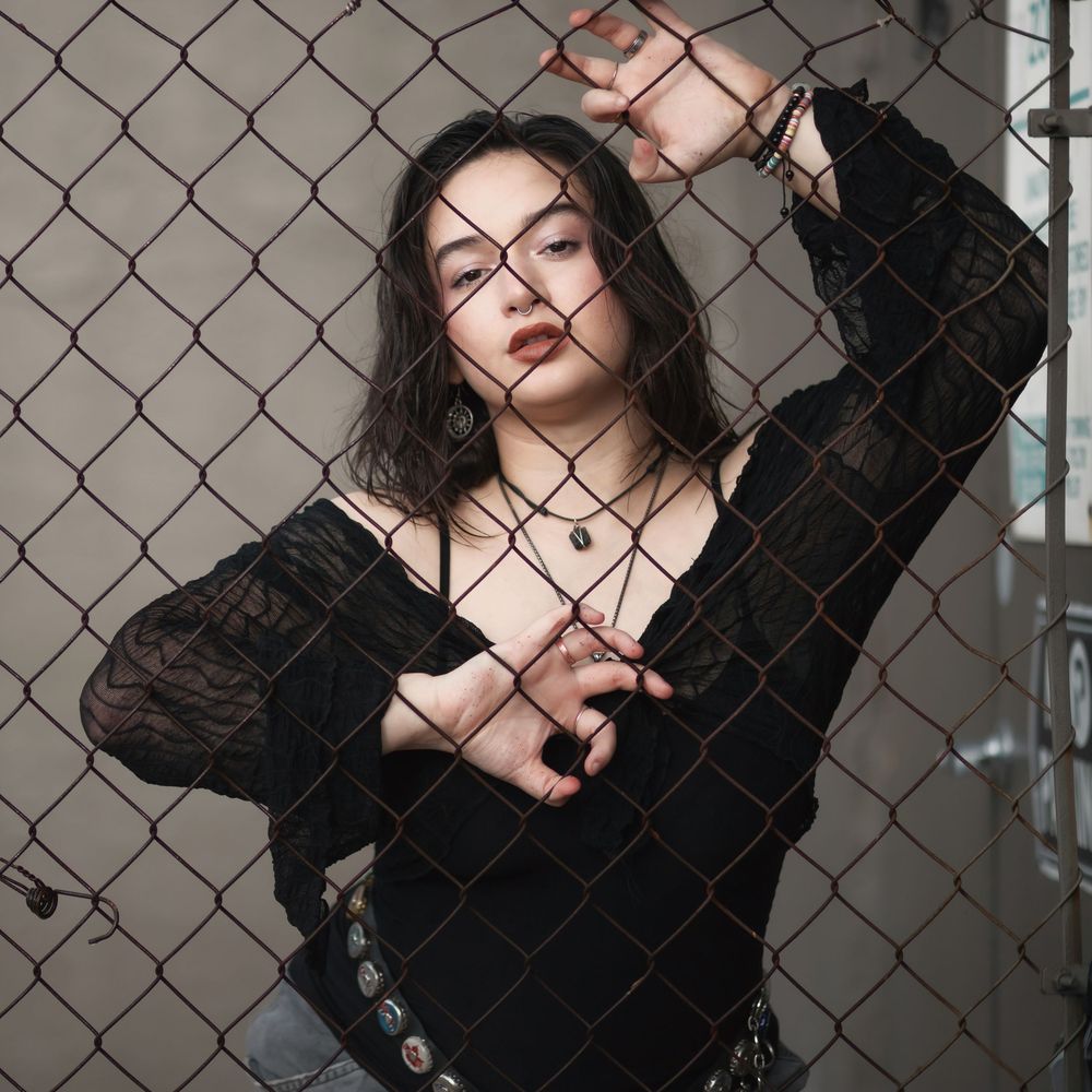 Fashion portrait of woman behind chain link fence at Hammocks Town Center in Miami