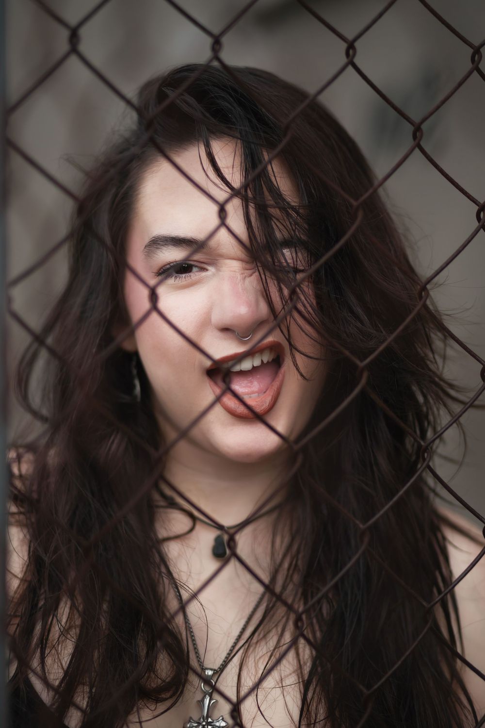 Fashion portrait of woman behind chain link fence at Hammocks Town Center in Miami
