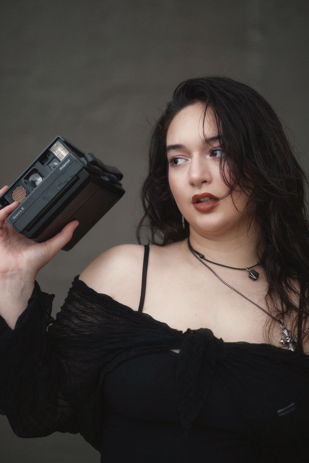 Fashion portrait of woman holding polaroid camera at Hammocks Town Center in Miami
