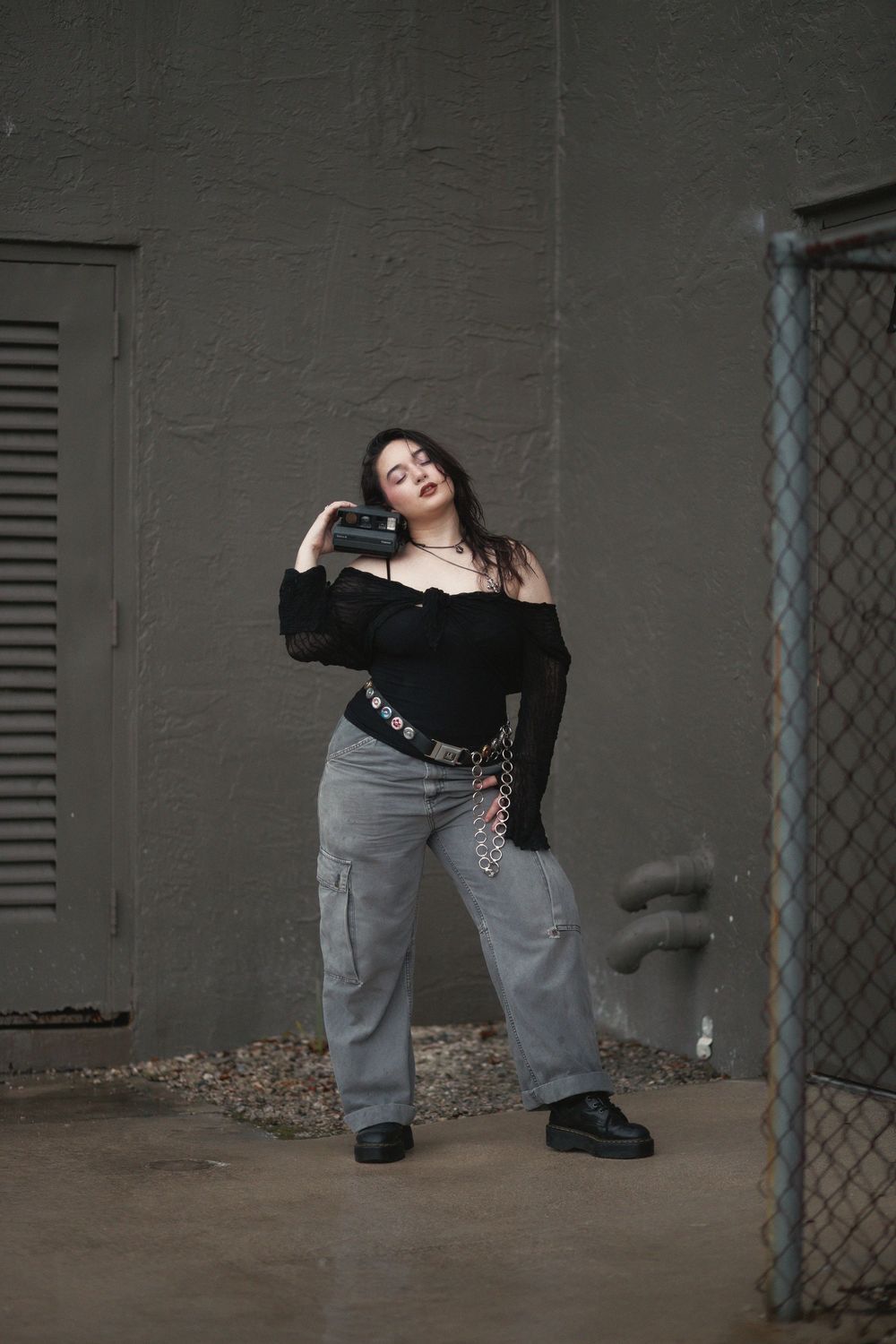 Fashion portrait of woman holding polaroid camera at Hammocks Town Center in Miami