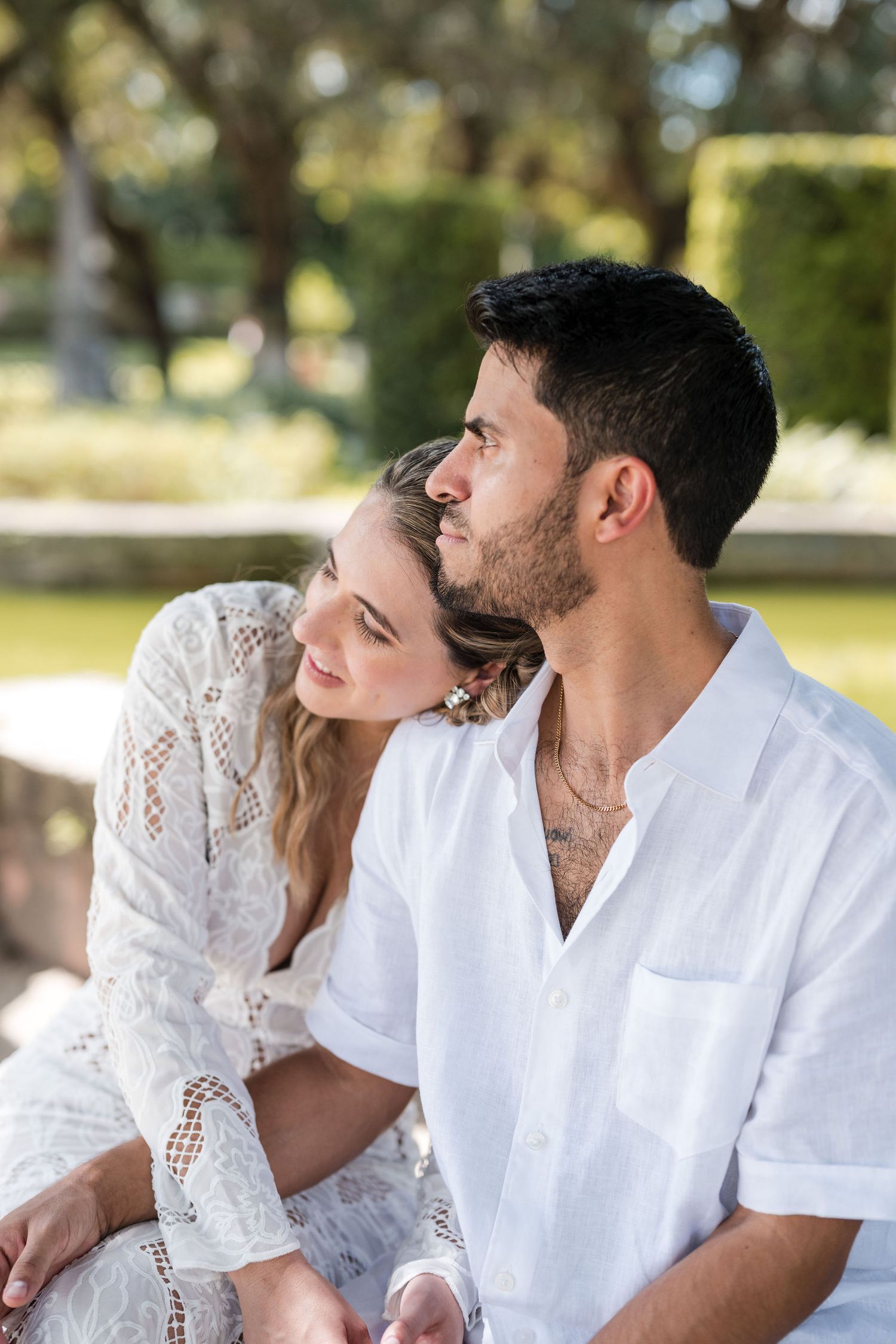 Bride rests her head on the groom’s shoulder as they share a quiet moment together in the gardens at Vizcaya.