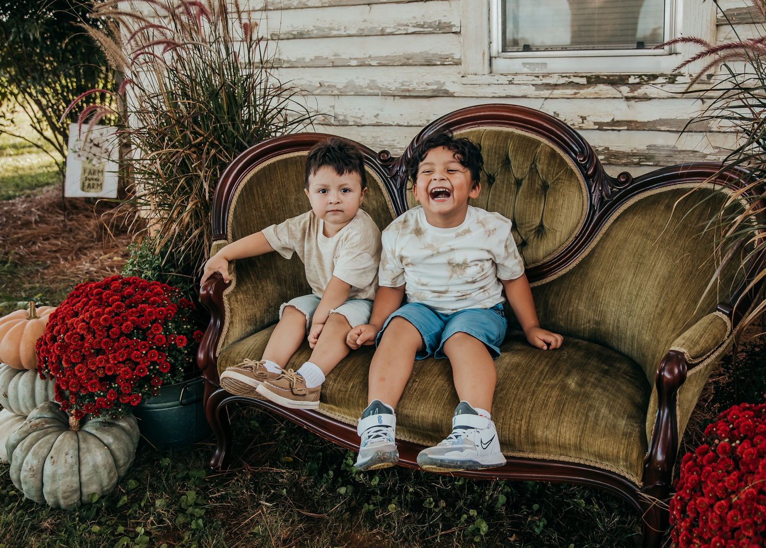 A playful family moment captured on vintage furniture with fall decorations and pumpkins.