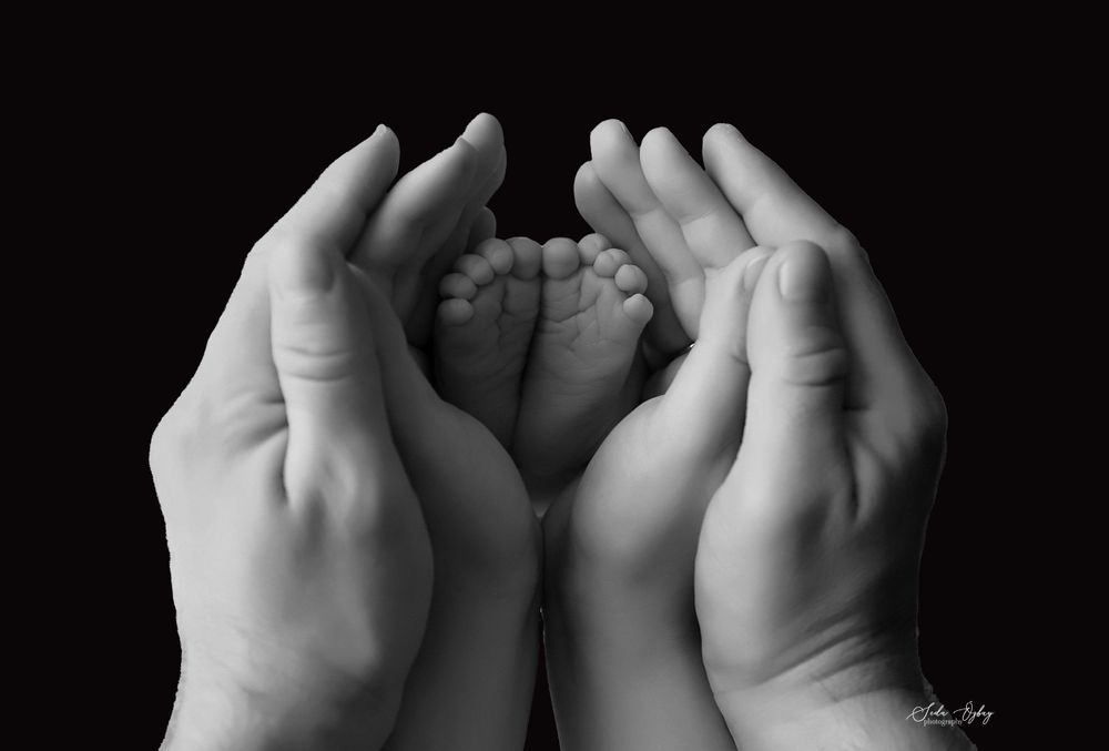Black and white close-up series of tiny baby hands and feet.