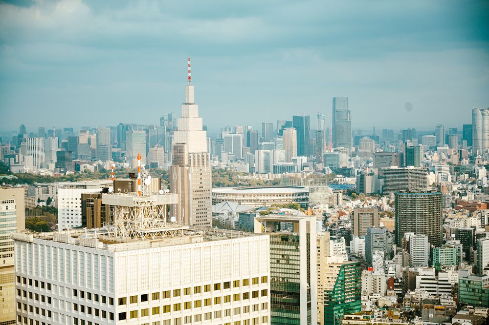 Panoramic skyline view of Tokyo cityscape with modern skyscrapers and office buildings on a cloudy day.