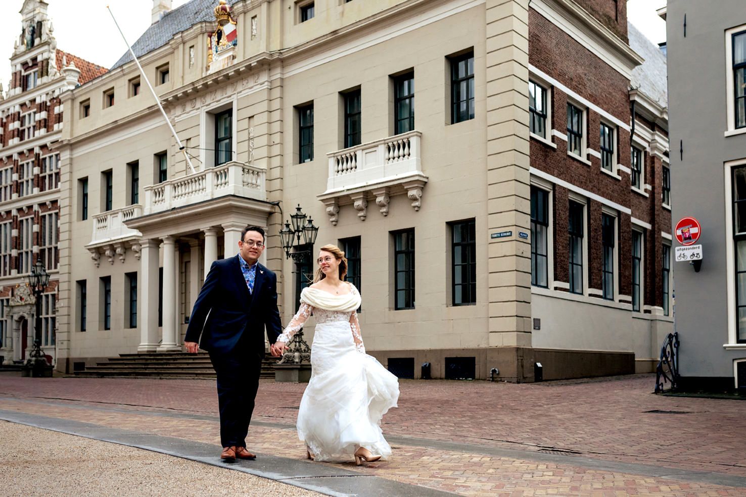 Bruidspaar loopt langs het stadhuis van Deventer na de fotoreportage op weg naar het trouwfeest