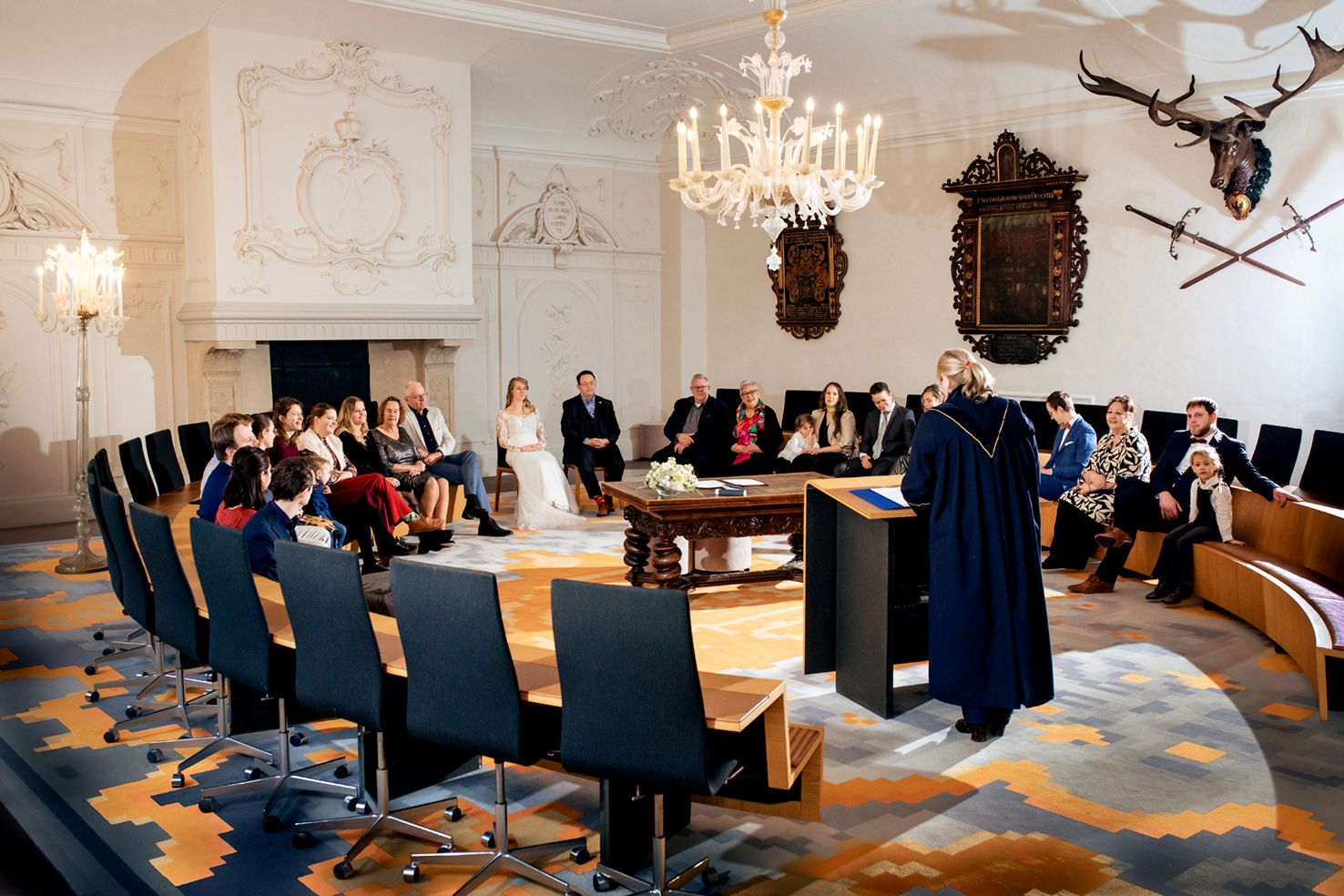 Overzicht van alle bruiloftsgasten in de trouwzaal van het gemeentehuis van Deventer tijdens de ceremonie