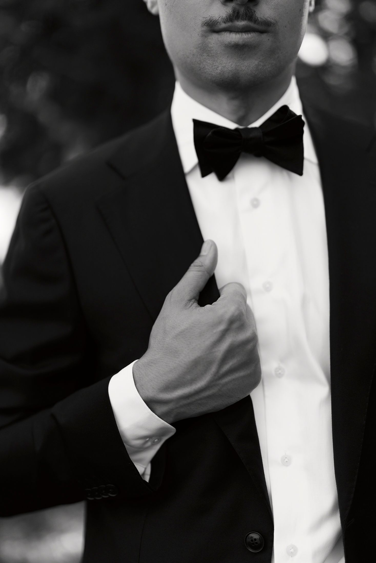 Close-up black and white photo of a tuxedo and bow tie showing formal menswear details.
