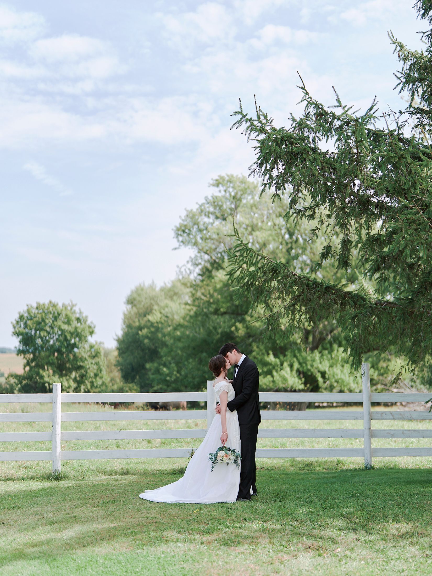 A couple shares romantic moments in a series of outdoor photos on a grassy lawn with trees in the background.