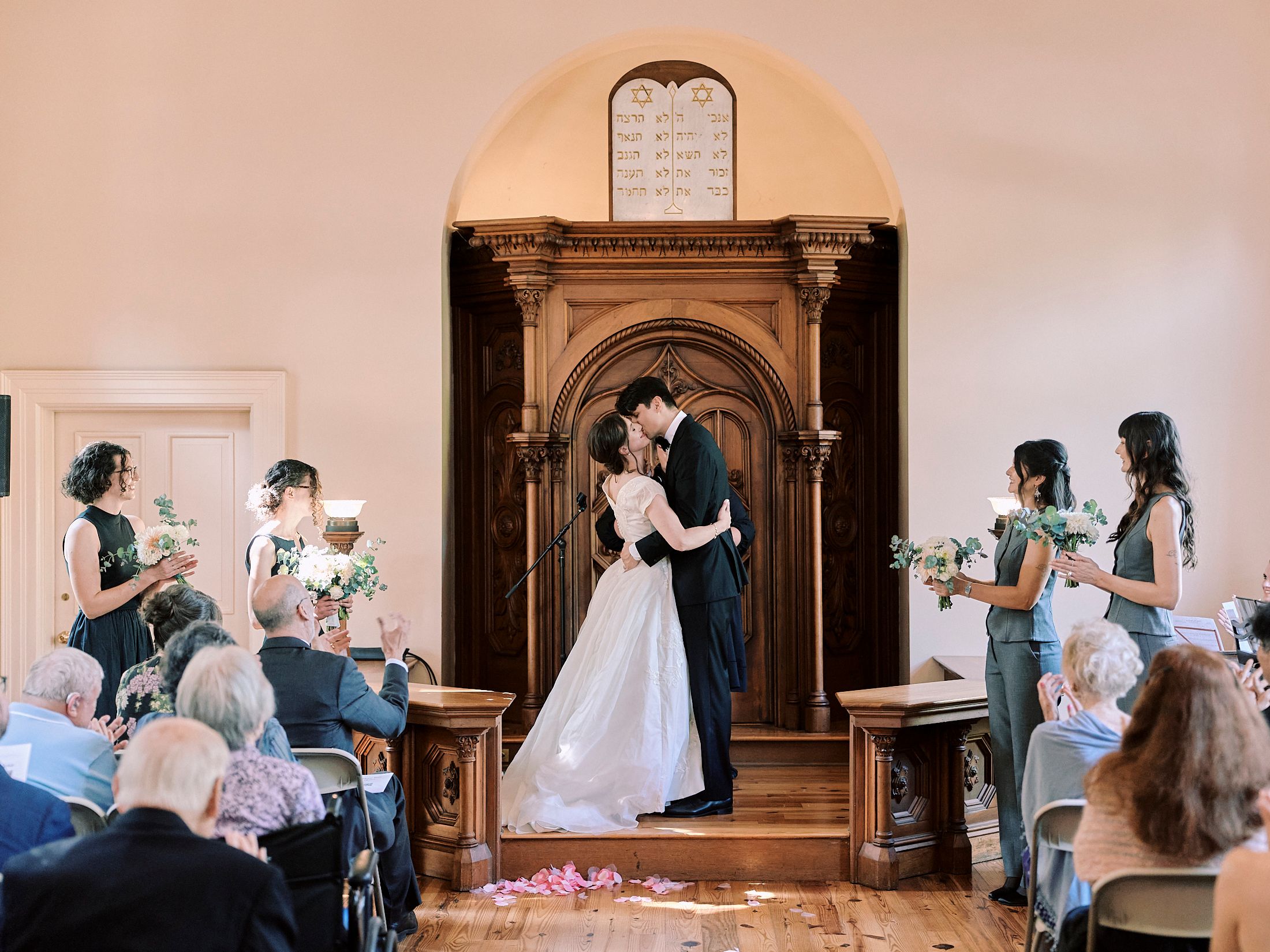Wedding ceremony taking place inside a historic chapel with wooden details.