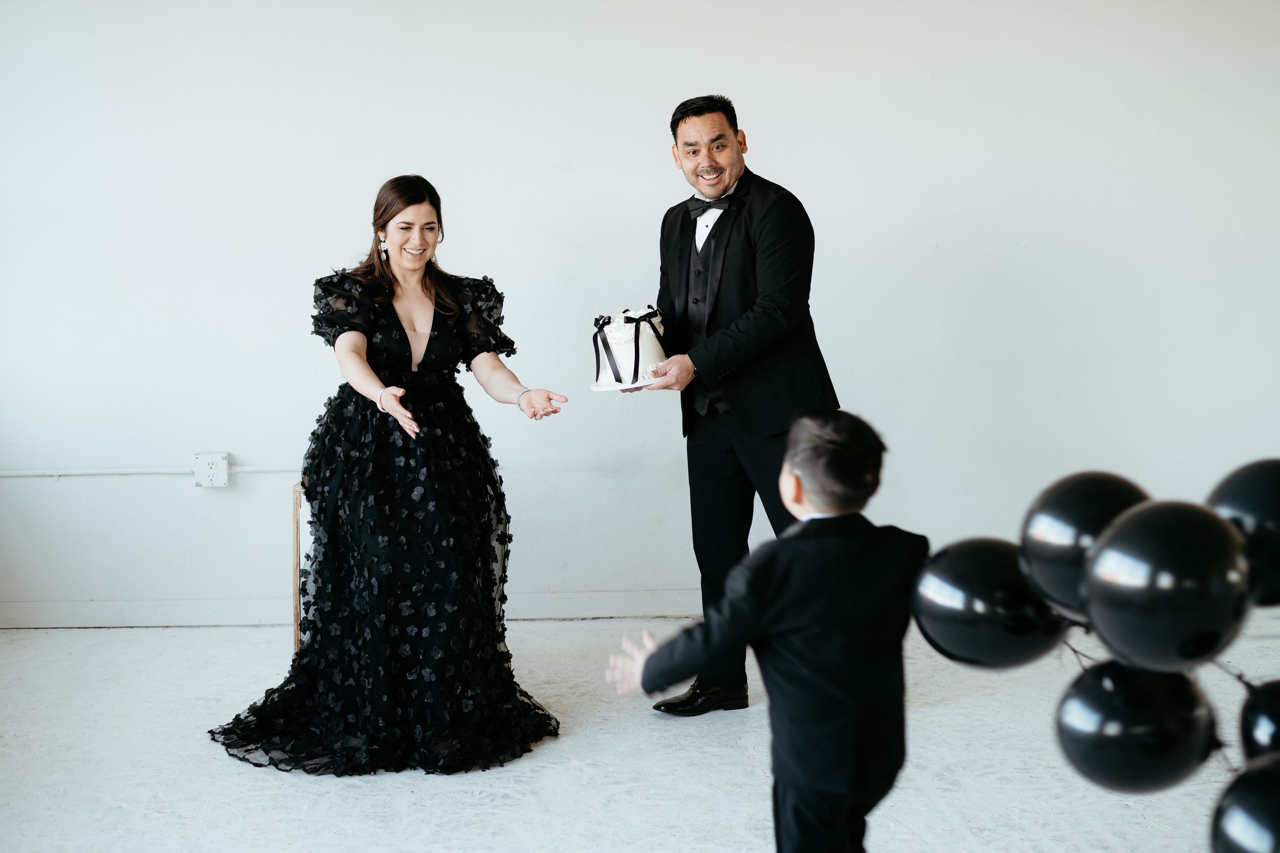Romantic couple in formal black attire pose together in an intimate photoshoot series.