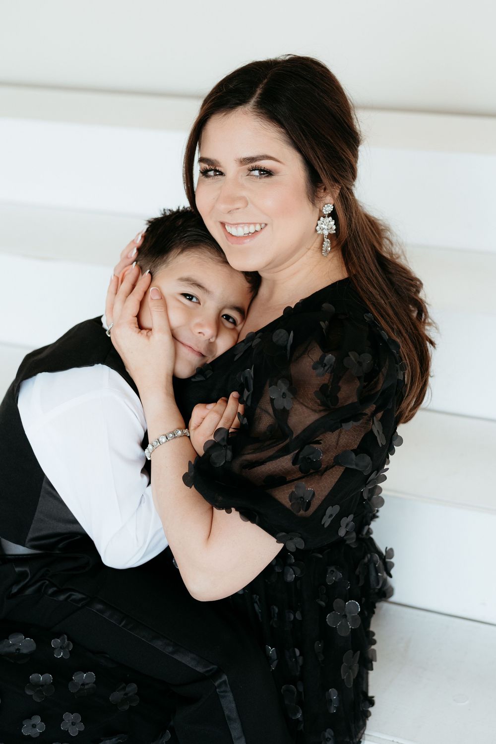 Mother and child share affectionate moments on white couch during photo session.