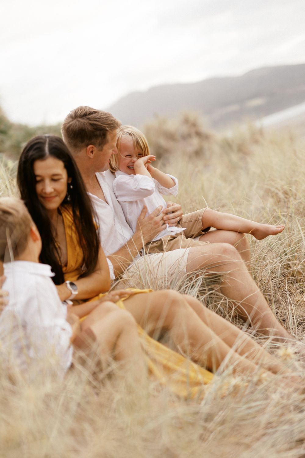 Intimate outdoor portrait session in golden grass during sunset.