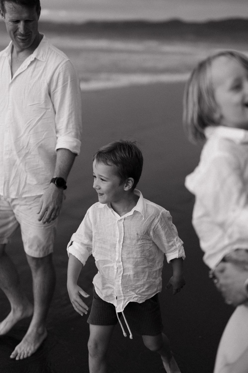 Black and white sequence showing a joyful child in a white shirt jumping and playing.