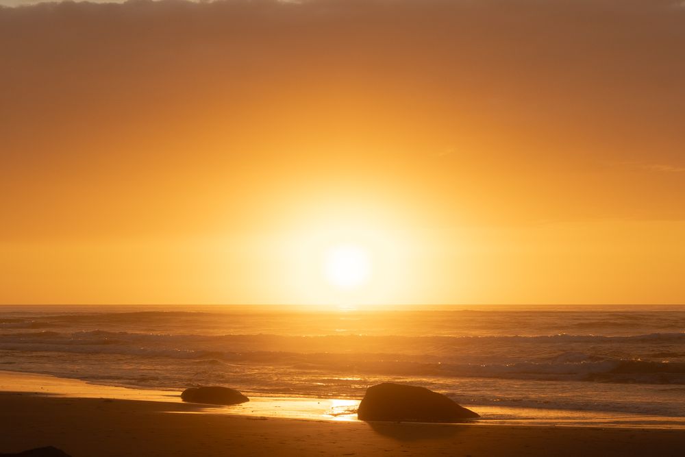 Panoramic view of a golden sunset over calm ocean waters.
