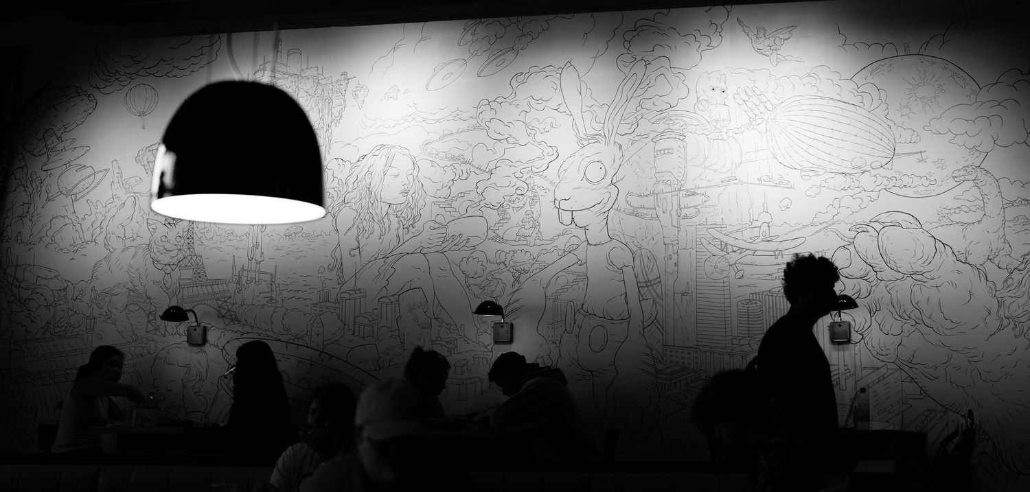 Dark silhouettes against a dimly lit background creating an atmospheric monochrome scene.