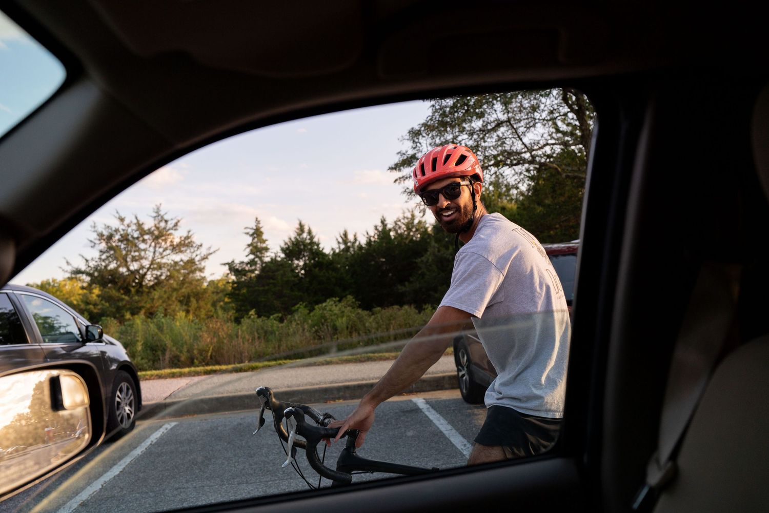 View through car window of a winding road during golden hour sunset.