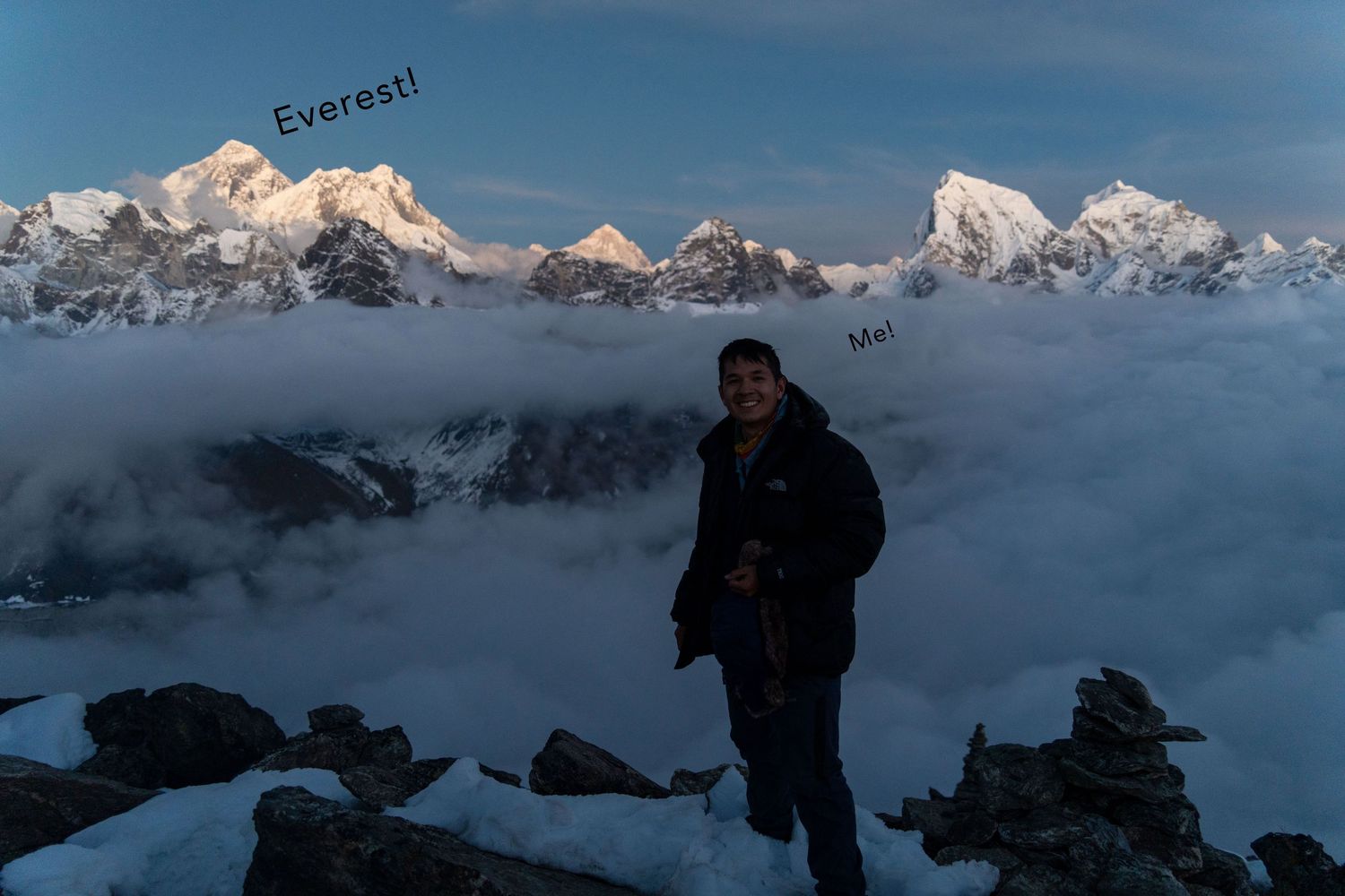 Snow-capped mountain peaks rising above clouds in bright sunlight.