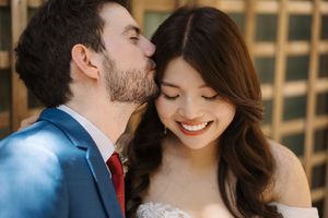 A romantic moment between newlyweds sharing tender expressions in an outdoor setting.