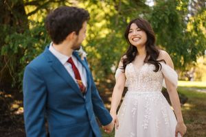 Candid wedding portraits showing joyful moments between a couple in a sun-dappled garden setting.