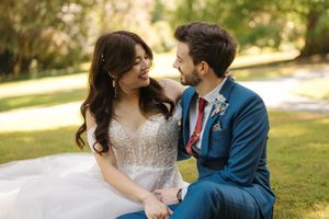 A romantic couple in wedding attire share tender moments during their outdoor garden photoshoot.