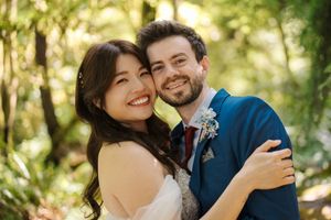 A couple shares warm embraces and romantic moments while taking photos outdoors in a natural setting.