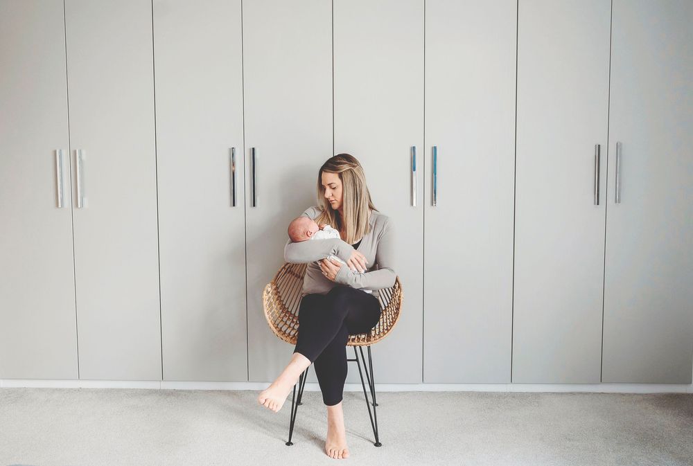Person exercising in white home gym with bean bag and cabinet storage area.