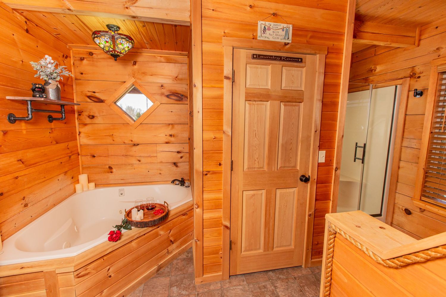 Log cabin hallway with wooden walls, exposed beams, and warm lighting fixtures.