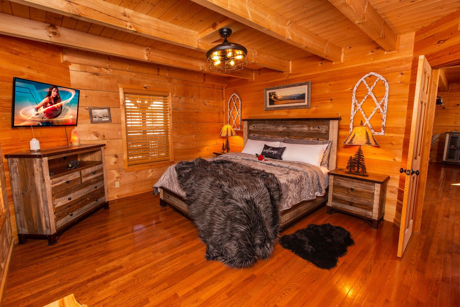 Spacious log cabin bedroom with wooden beams, rustic decor, and comfortable bedding.
