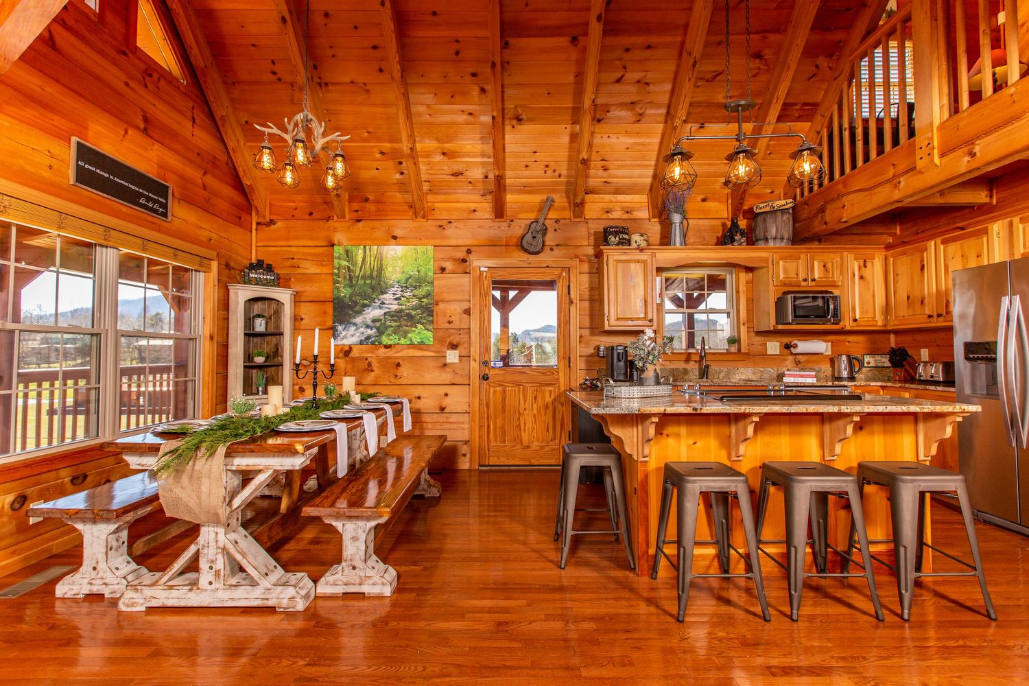 Open concept log cabin interior with vaulted ceilings, dining area, and natural wood throughout.