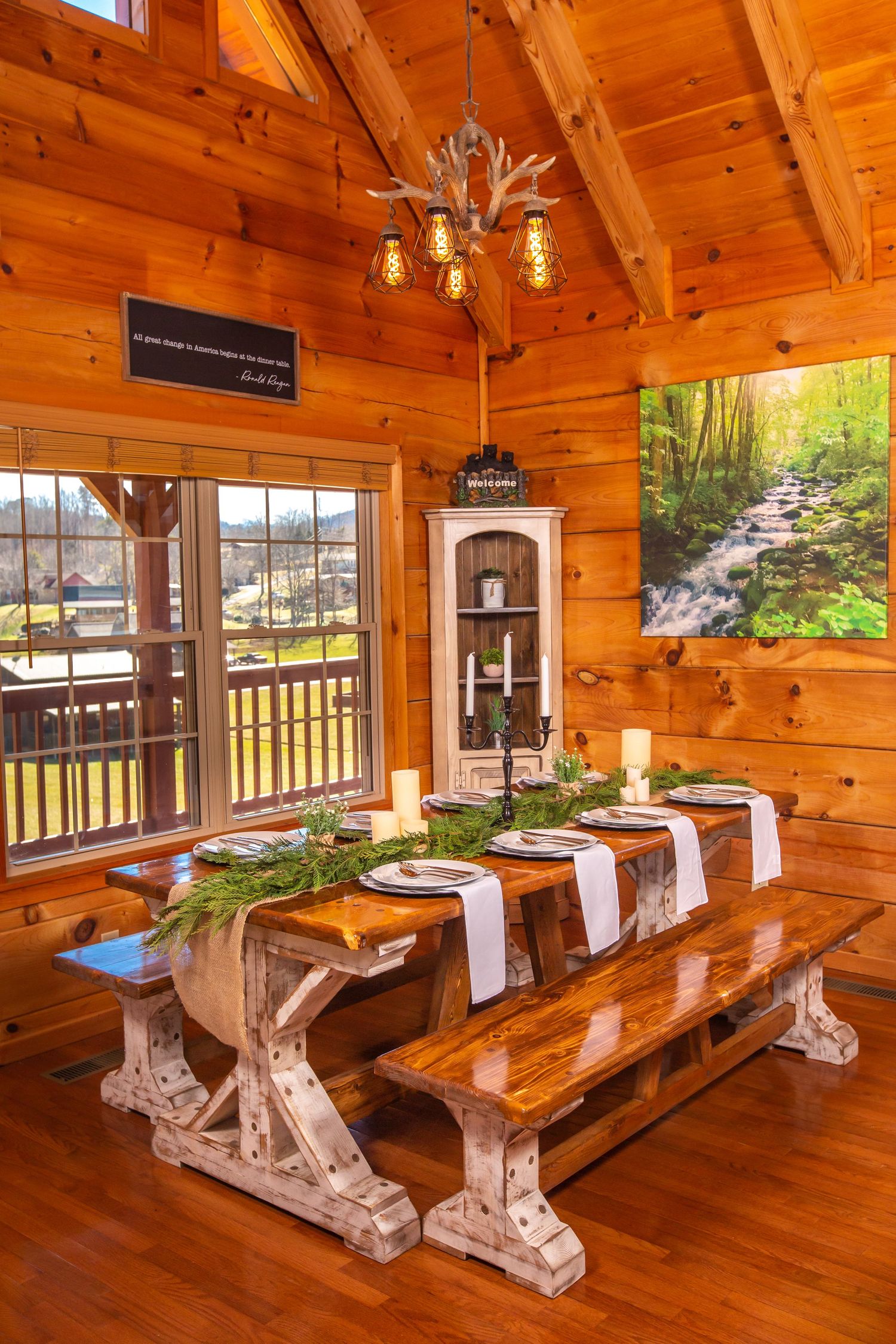 Dining area in log cabin with custom wooden benches and rustic table settings.
