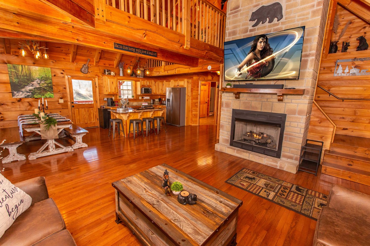 Cozy cabin living area featuring wood paneling, rustic decor, and bear-themed wall art.