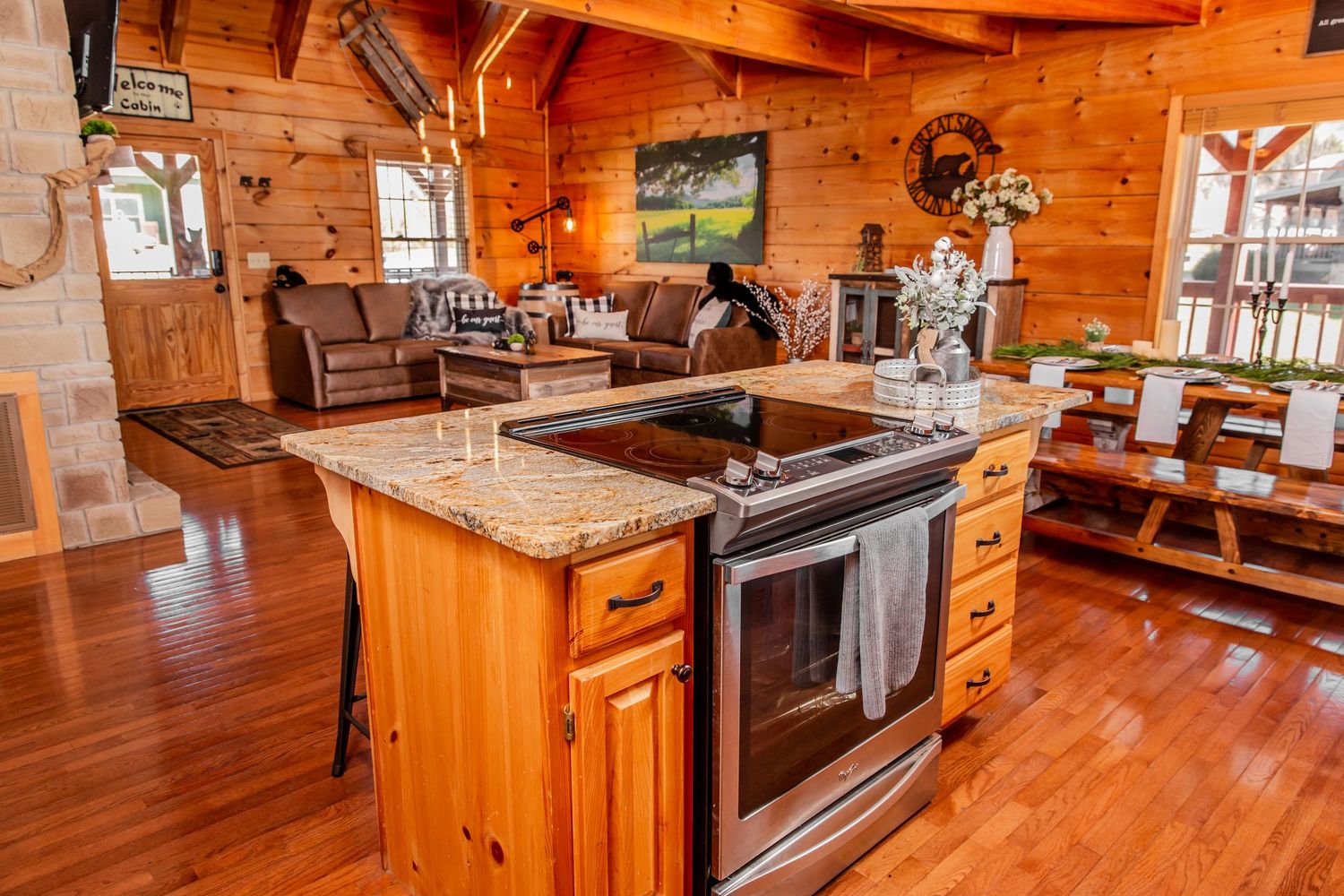 Modern kitchen with granite countertops and stainless steel appliances in an all-wood cabin interior.