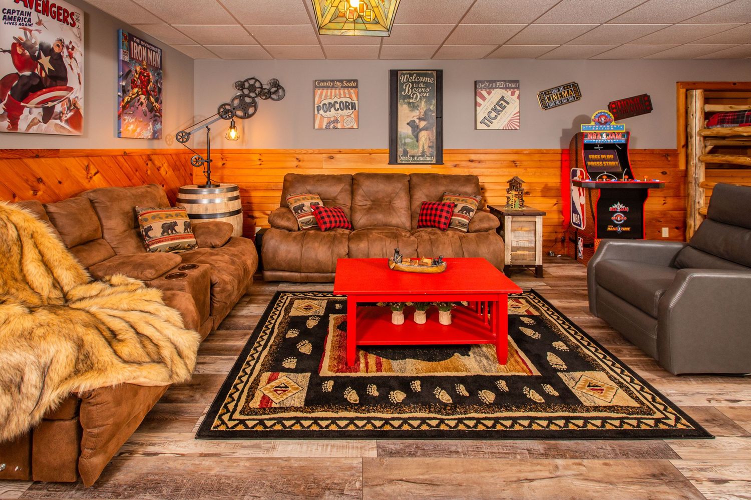 Basement recreation room with sports memorabilia, comfortable seating, and decorative area rugs.