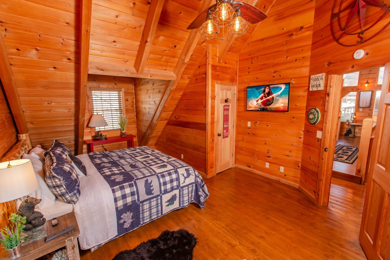 Cozy log cabin bedroom interior with warm wood paneling, rustic decor, and comfortable bedding.