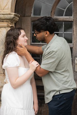 A romantic couple shares tender moments in a rustic building setting.