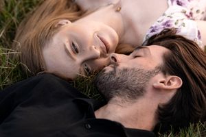 Intimate couple laying in grass during sunset photoshoot.